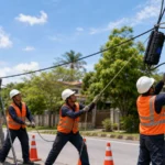 Kỹ thuật viên kéo và cố định cáp quang treo trên cột